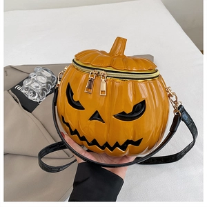 Detail of the high-shine pumpkin bag with dual gold zippers and Jack-o'-lantern face