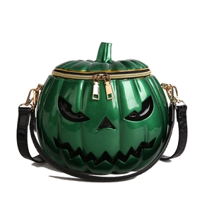 Detail of green pumpkin crossbody bag with gold zippers and jack-o-lantern face