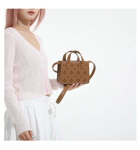 Détail du mini sac bandoulière en cuir marron grainé avec rivets décoratifs tendance