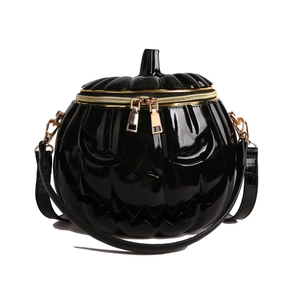Detail of glossy black pumpkin bag with embossed face and gold zipper hardware