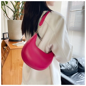 Detail view of fuchsia hobo crescent bag with golden metal hooks and premium PU texture