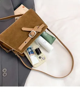 Détail du grand sac à bandoulière vintage en daim marron avec espace de rangement