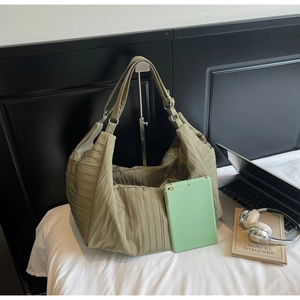 Large olive nylon dumpling bag detail showing spacious interior with laptop and tablet