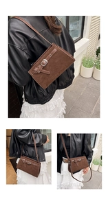 Détail d'un sac à bandoulière en daim marron foncé avec boucle et texture mate