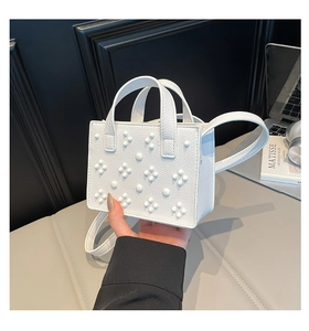 Détail du sac à main blanc en cuir grainé avec des décorations de perles en relief