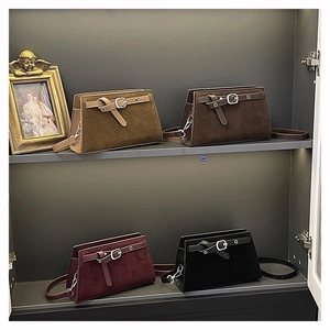 Gros plan de sacs bandoulière en daim vintage en kaki, marron, bordeaux et noir