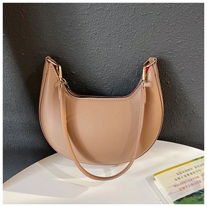 Detail showing contrast of khaki PU leather crescent bag with vibrant red interior lining