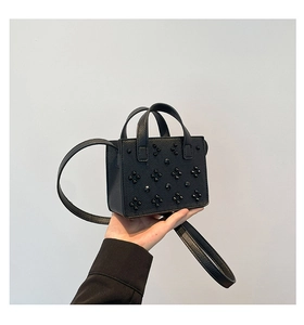 Détail du mini sac cabas en cuir grainé noir avec clous pyramides et bandoulière