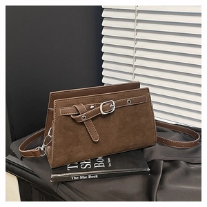 Détail du sac à bandoulière en cuir et daim marron foncé avec boucle argentée sur soie