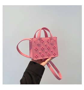 Détails du sac cabas rose avec texture cuir litchi et motifs cloutés en forme de fleurs