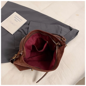 Interior view of brown suede tote bag showing burgundy lining and functional pockets
