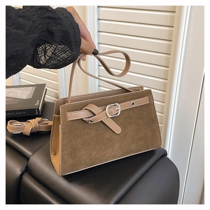 Détail du sac bandoulière en daim marron avec boucle métallique et fine sangle