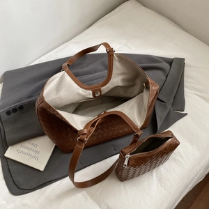 Detail of brown woven leather tote with magnetic closure and matching small pouch