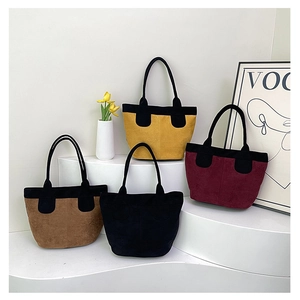 Detailed display of vintage suede tote bags in four color combinations on a shelf