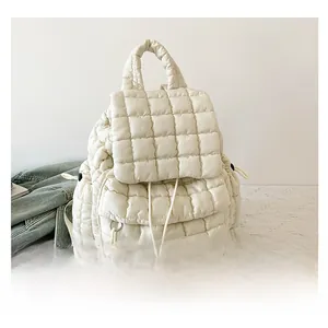 Macro view of cream quilted backpack with glossy finish and drawstring flap closure details