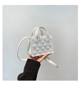 Détail du mini sac blanc avec rivets floraux 3D et texture en cuir grainé lychee