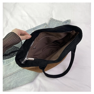Interior view of large tote bag with brown lining and secure metal zipper pocket