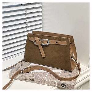 Détail du sac à rabat en daim kaki foncé avec boucle et garniture argentée