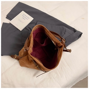 Detail of spacious retro suede shoulder bag interior with multiple functional pockets