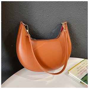 Detail of a brown crescent shoulder bag with smooth leather and gold hardware