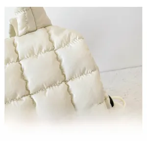 Detail of cream white quilted cloud bag featuring soft padded square stitching texture