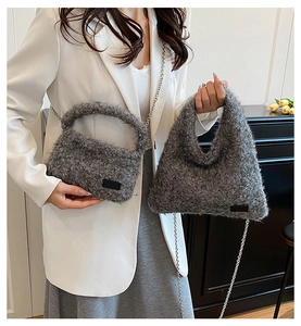 Detail of grey teddy fleece handbag with metal chain strap and minimalist black leather label