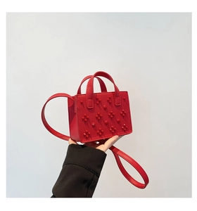 Gros plan du mini sac cabas rouge en cuir grainé avec décorations florales 3D
