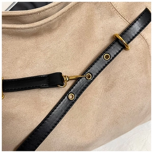 Macro detail of beige matte tote bag with golden metal hooks and black leather straps