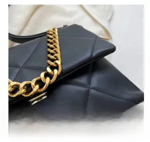 Detail van gewatteerde zwarte leren tas met strak stiksel en gouden ketting