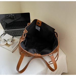 Brown matte leather tote bag interior view with zipper pocket and magnetic snap