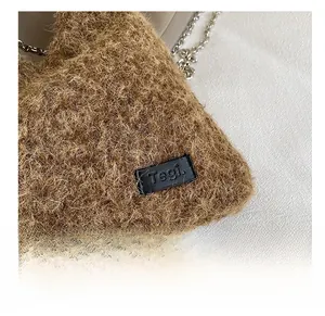 Detailed macro view of brown faux fur texture and silver metal chain strap on handbag