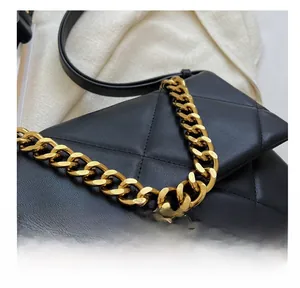 Detail van de zwarte gewatteerde leren tas met een gouden ketting en verfijnde stiksels