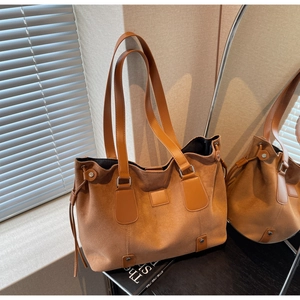 Detail of vintage matte leather tote bag featuring suede texture and side drawstring