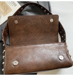Détail du sac à bandoulière marron avec rivets argentés et fermeture à pression aimantée