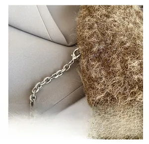 Detail view of the silver metal lobster clasp and plush brown faux fur texture