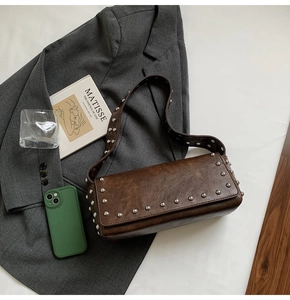 Détail du sac sous le bras en cuir marron vintage avec des clous argentés élégants