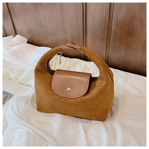 Détail d'un sac à main en daim marron avec rabat en cuir et bouton pression argenté