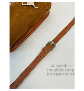 Detail view of brown suede handbag featuring adjustable silver buckle and premium leather strap