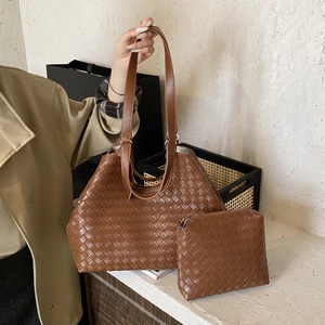 Detailed view of the woven brown leather tote bag with matching zipper pouch