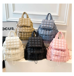 Quilted puffer backpacks in five colors displayed on a white minimal podium