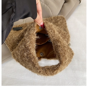 Detail view of the brown plush bag with metal chain strap and magnetic snap closure