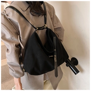 Detail of black large capacity fabric shoulder bag showing slouchy shape and leather straps