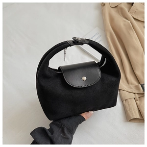 Détail du sac à main noir en daim et cuir lisse avec boucle argentée et fermeture