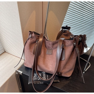 Detailed mirror view of a large brown suede tote bag with leather straps and drawstring
