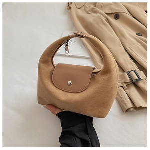 Détail du sac à main minimaliste en daim camel avec boucle argentée et fini texturé