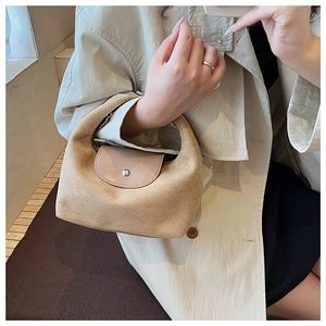 Vue détaillée du sac à main en daim camel avec rabat en cuir et fermoir en métal argenté