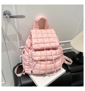 Detailed close-up of pink quilted puffer backpack featuring soft texture and drawstring closure