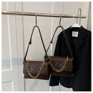Détail de sacs en cuir matelassé marron avec chaîne dorée épaisse et surpiqûres