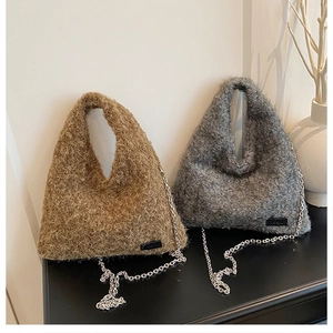 Close-up of brown and grey plush tote bags with silver chain straps and lamb wool texture