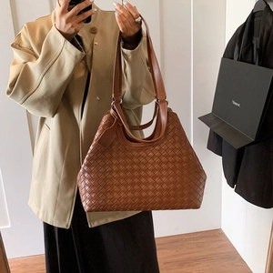 Detailed view of the brown leather woven texture on a large minimalist tote bag